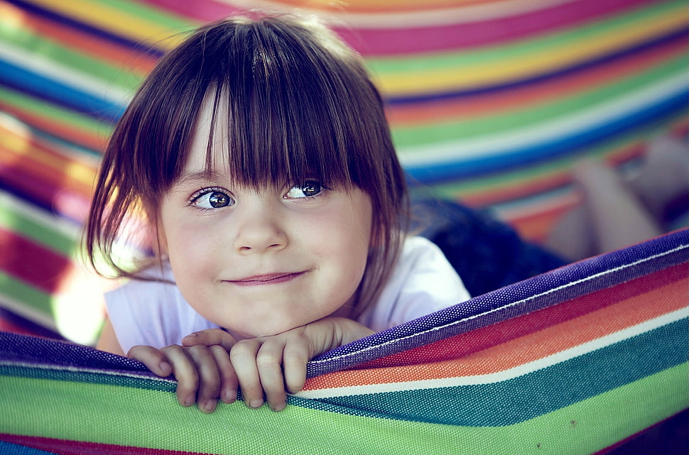 girl smiles while lying in multicolored hammock HD wallpaper
